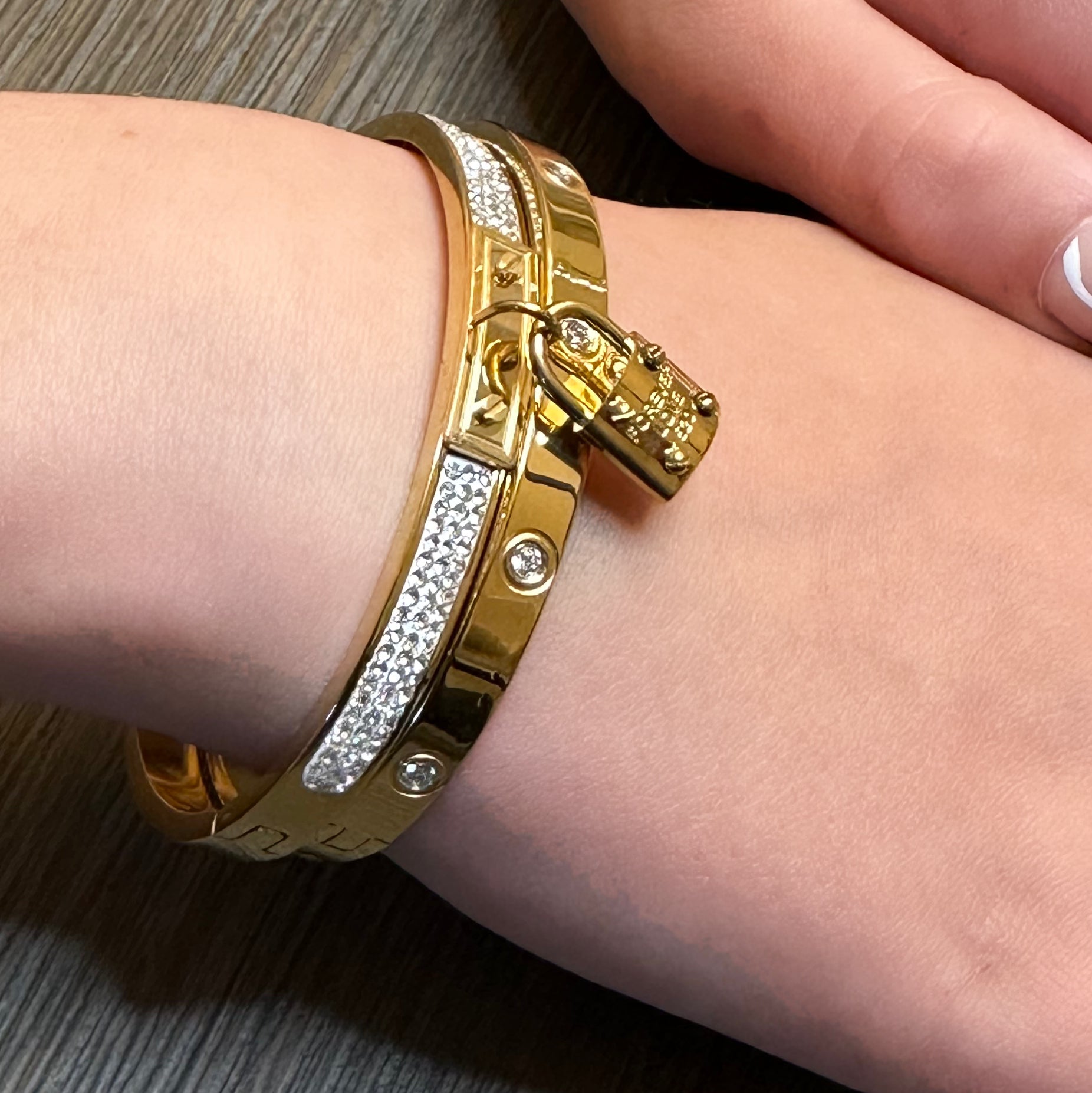 gold bangle bracelet with a lock charm and gold bangle with cubic zirconia